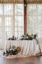 Elegant wedding table in the style of vintage and rustic decorated with flowers, white lace, tablecloth and candles Royalty Free Stock Photo