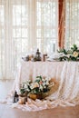 Elegant wedding table in the style of vintage and rustic decorated with flowers, white lace, tablecloth and candles Royalty Free Stock Photo