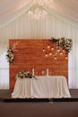 Elegant wedding table in a tent with chandelier and flowers