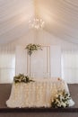 Elegant wedding table in a tent with chandelier and flowers