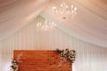 Elegant wedding table in a tent with chandelier and flowers