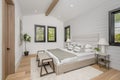 Elegant white bedroom features traditional wood flooring and a tall headboard