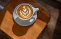 An elegant white cappuccino cup on wooden surface.