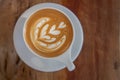 An elegant white cappuccino cup on wooden surface.