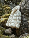 Elegant White Down Jacket Displayed on Mossy Rock Background Royalty Free Stock Photo