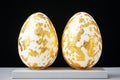 Elegant white eggs with gold leaf decoration on black background. Royalty Free Stock Photo