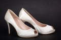 Elegant white female shoes on dark background