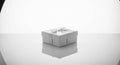 Elegant White Gift Box with a Delicate Ribbon on a Reflective Surface Royalty Free Stock Photo