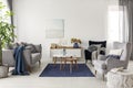 Elegant white, grey and blue living room interior with scandinavian sofa and velvet armchair Royalty Free Stock Photo