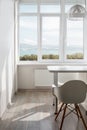 Elegant white kitchen room with chair and scenic sea and mountain views. Scandinavian modern design concept, interior detail