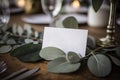 Elegant White Name Card on Eucalyptus Wedding Table. Perfect for Place Settings and Table Decor. Royalty Free Stock Photo