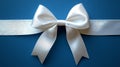 a pristine white satin ribbon tied into a beautiful bow, centered on a deep blue background, creating a sense of elegance and cele Royalty Free Stock Photo