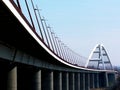 Elegant white steel arched bridge with tilted street lights