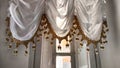 Elegant Window Drapes With Tassel Trim Overlooking. White sheer curtains with decorative tassels framing window