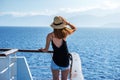 Elegant woman with casual dress and hat on a ferry boat on the Aegean sea, Cyclades, Greece Royalty Free Stock Photo