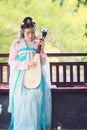 Elegant woman in Chinese traditional drama ancient costume play Chinese lute pipa guitar Royalty Free Stock Photo