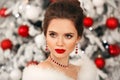 Elegant woman Cristmas portrait. Beautiful brunette lady with ruby jewelry set and wedding hairstyle, beauty makeup wears posing Royalty Free Stock Photo