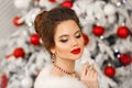 Elegant woman Cristmas portrait. Beautiful brunette lady with ruby jewelry set and wedding hairstyle, beauty makeup wears posing Royalty Free Stock Photo