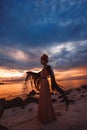 Elegant woman dancing on water. Sunset and silhouette Royalty Free Stock Photo