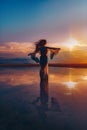 Elegant woman dancing on water. Sunset and silhouette Royalty Free Stock Photo