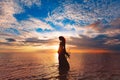 Elegant woman dancing on water. Sunset and silhouette Royalty Free Stock Photo