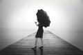 Elegant woman dressed in black hiding with umbrella