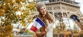 Elegant woman on embankment near Eiffel tower showing flag Royalty Free Stock Photo