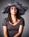 Elegant Woman Face Portrait hidden by Black Hat. Beauty Fashion Model with Red Lips and Eye Make up over dark Gray Royalty Free Stock Photo