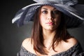 Elegant Woman Face Portrait hidden by Black Hat. Beauty Fashion Model with Red Lips and Eye Make up over dark Gray Royalty Free Stock Photo