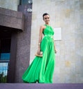 Elegant woman in green dress posing against a concrete wall Royalty Free Stock Photo