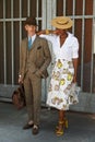 Elegant woman with man with brown suit with hat before Fendi fashion show, Milan Fashion Week street style on Royalty Free Stock Photo