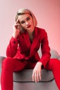 elegant woman in red clothes posing in armchair Royalty Free Stock Photo