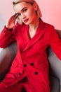 elegant woman in red clothes posing in armchair, Royalty Free Stock Photo