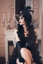 Elegant woman in retro style of the 20s, lady flapper in a black dress, dark hair and a bandage, feather boa, long