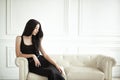 Elegant Woman sitting on white leather sofa