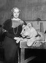 Elegant woman standing next to a lion