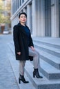 An elegant woman in a stylish outfit poses on a city street Royalty Free Stock Photo