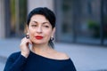 An elegant woman in a stylish outfit poses on a city street Royalty Free Stock Photo