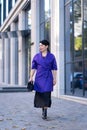 An elegant woman in a stylish outfit poses on a city street Royalty Free Stock Photo