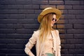 Elegant woman in sunglasses on a street walk urban style brick background