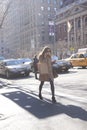 Elegant woman talking on her phone crossing the street in New York