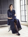 Elegant woman wearing denim suit sitting in studio Royalty Free Stock Photo