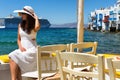 Elegant woman in white sits at the waterfront of Little Venice in Mykonos, Greece Royalty Free Stock Photo