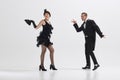 Elegant woman and man in retro attire engage in fun, choreographed dance, evoking the spirit of bygone era isolated over