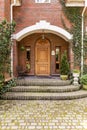 Elegant, wooden entrance door to an estate with ivy growing on b