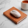 Elegant workspace setup featuring a modern mouse resting on a leatherbound notebook Royalty Free Stock Photo