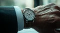 Elegant wristwatch resting on a well-groomed hand during a business meeting indoors