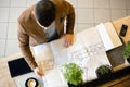 Young architect looking at building floor plans. High angle view Royalty Free Stock Photo