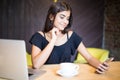 Elegant young smile woman with a laptop computer at a cafe using a mobile phone . Royalty Free Stock Photo