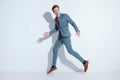 Elegant young businessman in blue suit leaping up in the air Royalty Free Stock Photo